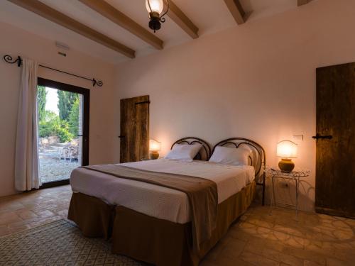 um quarto com uma cama e uma grande janela em La Guest House della Tenuta di Tavignano em Cervidone