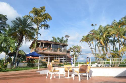 a resort with a table and chairs and a building at Finca Hotel Valparaíso in Armenia
