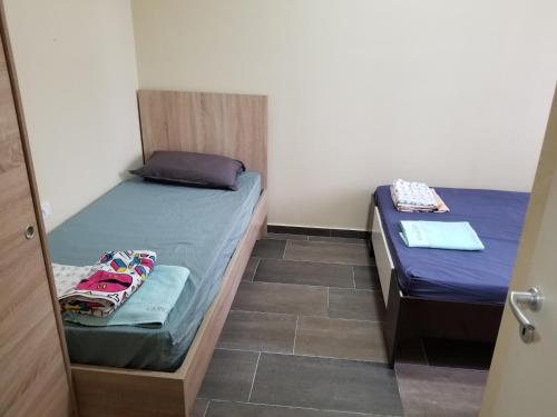 two twin beds in a room with a door open at Beach Garden Home, Lalzi Bay in Durrës
