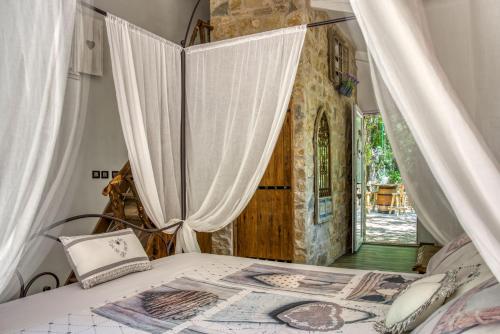 1 dormitorio con 1 cama con cortinas blancas y puerta en Domaine de l'Insolite en Méounes-lès-Montrieux