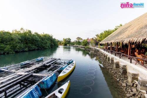 Chaiyo Resort في فوكيت تاون: ثلاث سفن راسية على نهر بجوار مبنى