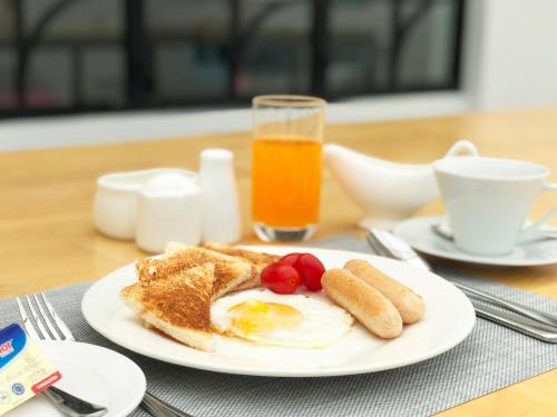 a plate with an egg and toast and a glass of orange juice at HOOD Hostel in Yangon