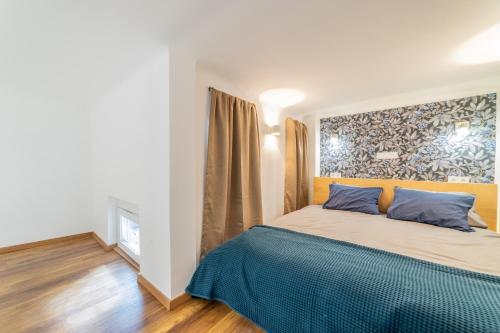 a bedroom with a large bed with blue pillows at Paulay Boutique Residences Downtown in Budapest