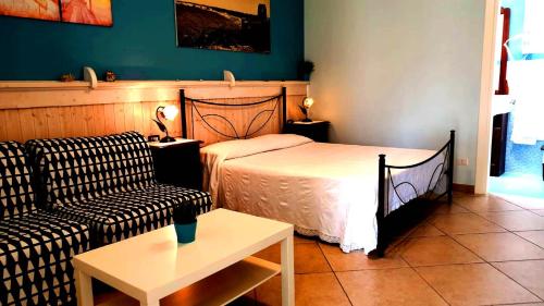 a bedroom with a bed and a couch and a table at B&B Villa Romina in San Cataldo
