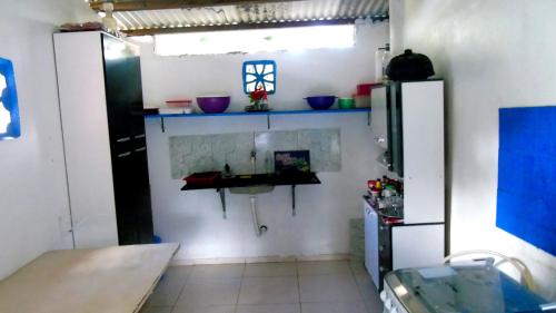 a room with a refrigerator and some bowls on the wall at Casa do Mestre Avila in Jijoca de Jericoacoara