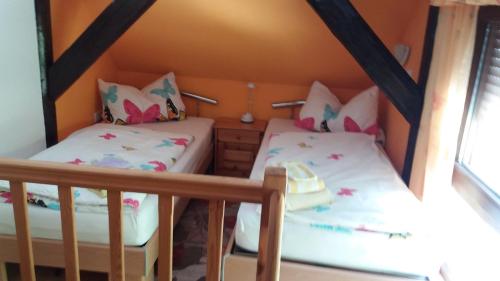 2 Einzelbetten in einem Zimmer mit 2 Fenstern in der Unterkunft Ferienwohnung Tihsies in Seddin