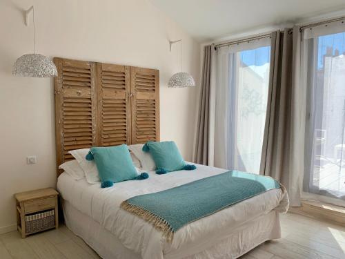 une chambre avec un grand lit avec des oreillers bleus dans l'établissement La Maison Odeia Bordeaux Centre, à Bordeaux