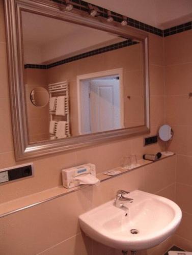 a bathroom with a sink and a mirror at Hotel Sprenz in Oldenburg
