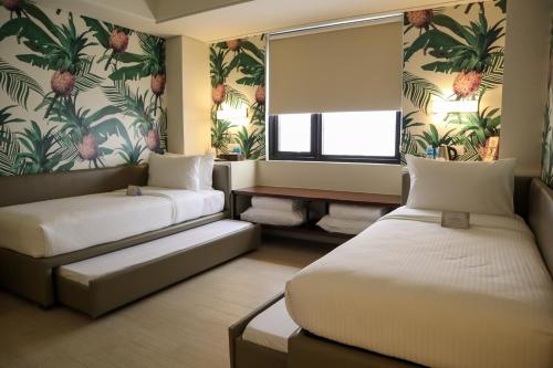 a hotel room with two beds and a window at Mella Hotel in Manila
