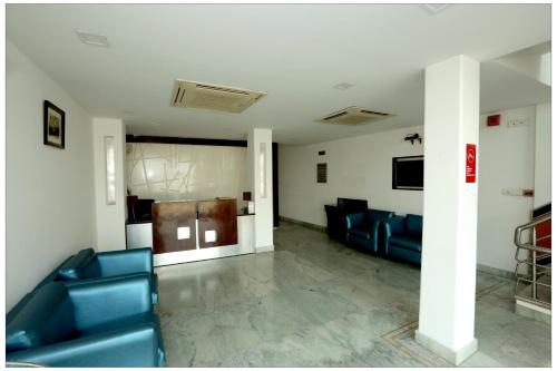 uma sala de espera com cadeiras azuis num edifício em Airport Hotel The R Blues - New Delhi em Nova Deli