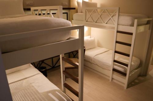 a room with two bunk beds and a couch at Mella Hotel in Manila