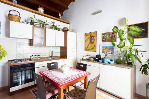 eine Küche mit weißen Schränken und einem Tisch mit Stühlen in der Unterkunft Anna's Home in Historical Center in Palermo
