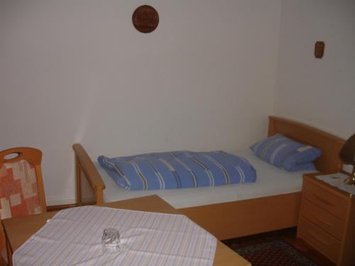 una camera da letto con un letto con cuscini blu e un tavolo di Gästehaus Sparenberg a Bad Krozingen