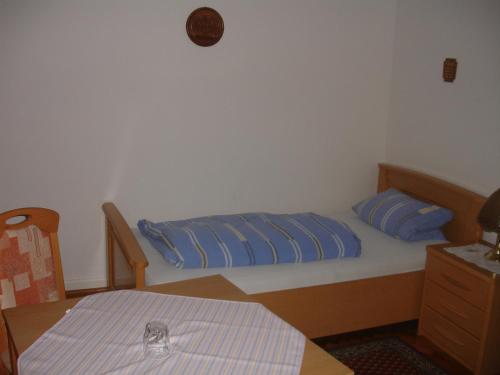 Schlafzimmer mit einem Bett mit blauen Kissen und einem Tisch in der Unterkunft Gästehaus Sparenberg in Bad Krozingen
