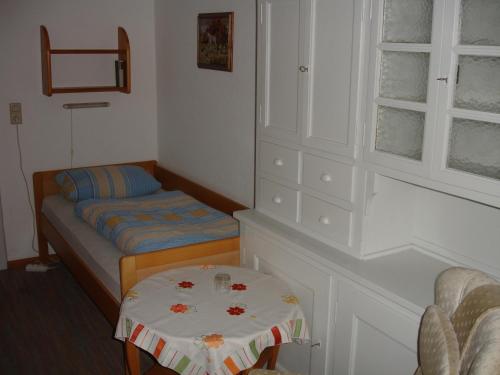 Kleines Zimmer mit einem Bett und einem Tisch in der Unterkunft Gästehaus Sparenberg in Bad Krozingen
