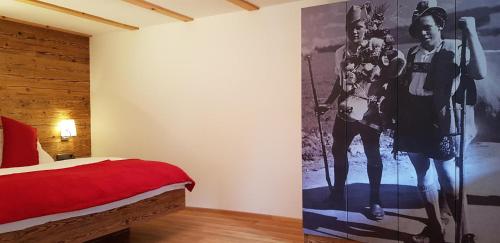 a bedroom with a red bed and a poster on the wall at Ferienwohnung Bader in Bolsterlang