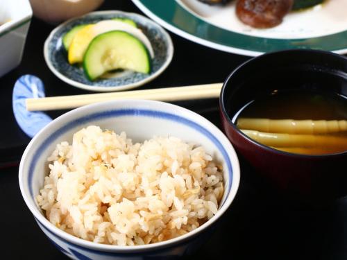 a bowl of rice and a bowl of soup and chopsticks at Hotel Mumon in Myoko