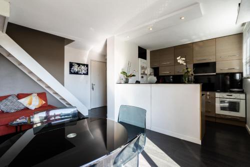 une cuisine et un salon avec une table et un comptoir dans l'établissement Monplaisir, à Toulouse