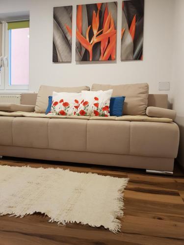 un sofá en una sala de estar con pinturas en la pared en Apartments Mojstrana - Kekec en Mojstrana