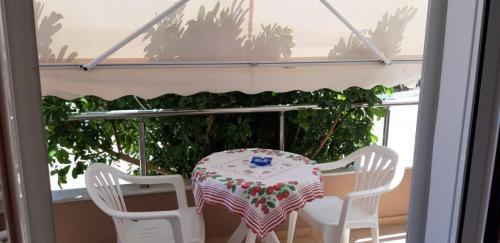 a table and four chairs sitting on a porch at Βlue Horizon Lixouri in Lixouri
