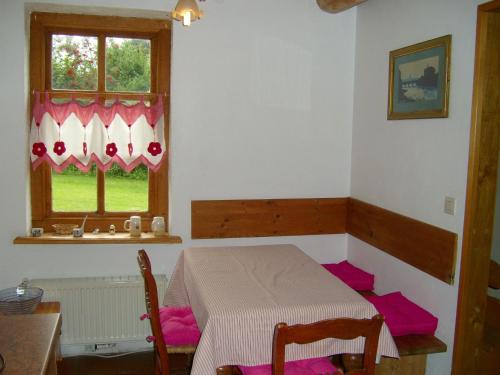 a dining room with a table and a window at Jabjemööh's Huus in Greetsiel