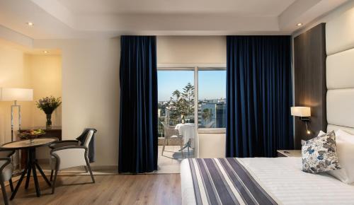 une chambre d'hôtel avec un lit, une table et des chaises dans l'établissement Ambassador Hotel, à Jérusalem