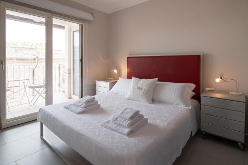 ein Schlafzimmer mit einem Bett mit zwei Handtüchern darauf in der Unterkunft La Boheme di Ortigia Luxury - Ortigia Holidays in Syrakus