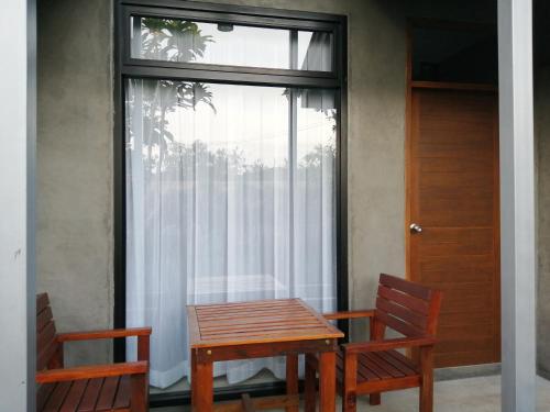 a table and two chairs in front of a window at JR Place in Klong Muang Beach