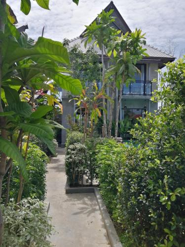 a house with trees and plants in front of it at JR Place in Klong Muang Beach
