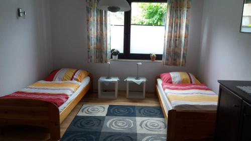two beds in a small room with a window at Ferienwohnung Im Waldwinkel in Stadthagen