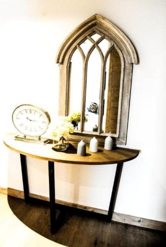 a table with a mirror and a clock on it at Luxury Grimentz Apartment in Grimentz