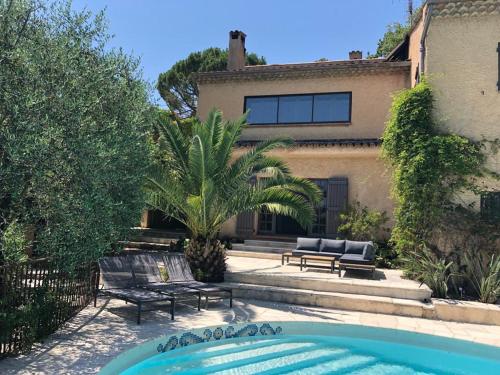 a house with a swimming pool in front of a house at Les Cypres in Mougins