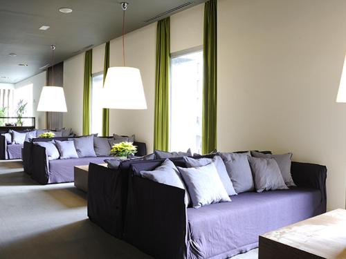 a living room with purple couches and windows at Blau Hotel Las Caldas in Las Caldas