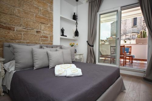 a bedroom with a bed with a brick wall at Mare Versus Luxury Suites in Barletta