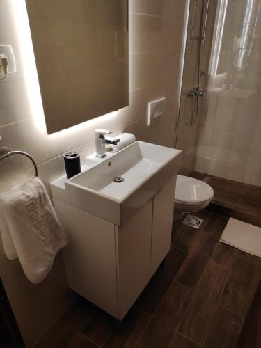 a bathroom with a white sink and a toilet at Accommodation Plitvice in Korenica