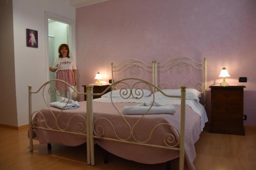 a girl standing in a bedroom with a bed at Il Ciclamino Bed and Breakfast in Ascoli Piceno