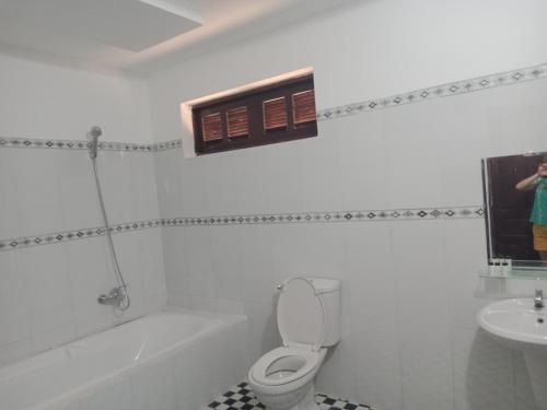 a white bathroom with a toilet and a sink at CocoPalm Villa near Beach - Coco Room in Hội Mỹ