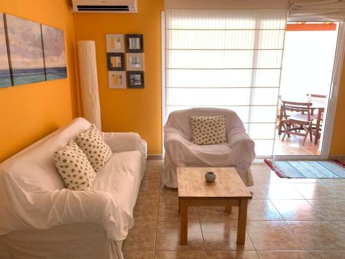 sala de estar con 2 sillas y mesa de centro en Ático Sun&Beach, en Gran Tarajal