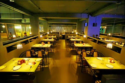 a restaurant with tables and chairs and people sitting at them at Hotel Swagath Grand Miryalaguda in Miriālgūda