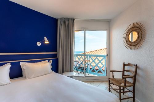a hotel room with a bed and a balcony at Hotel Paradou Mediterranee, BW Signature Collection by Best Western in Sausset-les-Pins