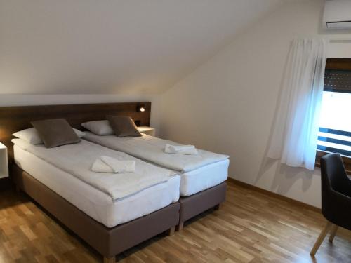 a bedroom with a large bed and a window at Accommodation Plitvice in Korenica