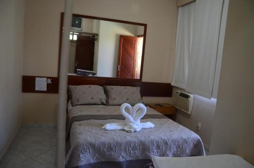 a bedroom with a bed with a white bunny on it at Hotel 3 Pontões in Afonso Cláudio