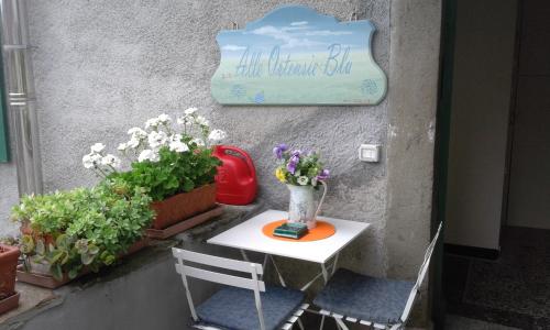 een tafel met een vaas erop naast enkele planten bij B&B Alle Ortensie Blu in Sesta Godano