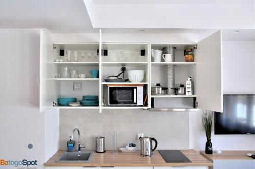 a kitchen with white cabinets and a microwave at BatogoSpot Tumski 2 in Wrocław