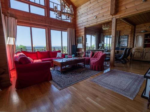 a living room with red furniture and large windows at Villa Lohusalo I with Sauna in Lohusalu