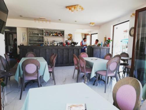 een restaurant met tafels en stoelen en een bar bij Sunset in Plataria