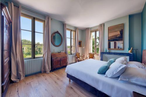 une chambre avec un lit avec des murs et des fenêtres bleus dans l'établissement Luxurious Wine Estate Saint-Emilion Grand Cru with private swimming pool, à Saint-Hippolyte