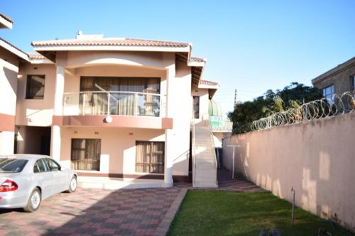 a white car parked in front of a house at Villa Prince in Harare