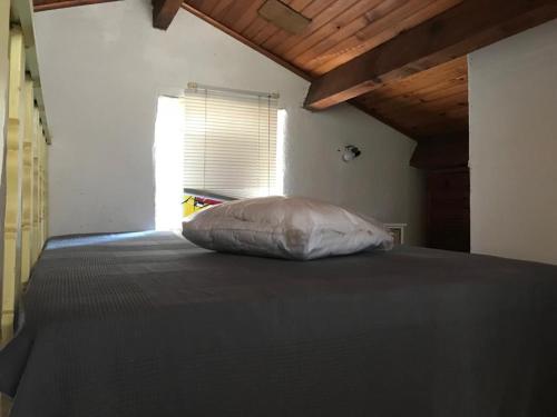 a bed with a pillow in a room with a window at Gîte Aghja suttana l'incantu in Santa-Lucia-di-Mercurio