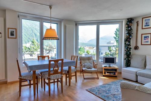 uma sala de estar com uma mesa e cadeiras e um sofá em Chesa Quadratscha - Samedan em Samedan